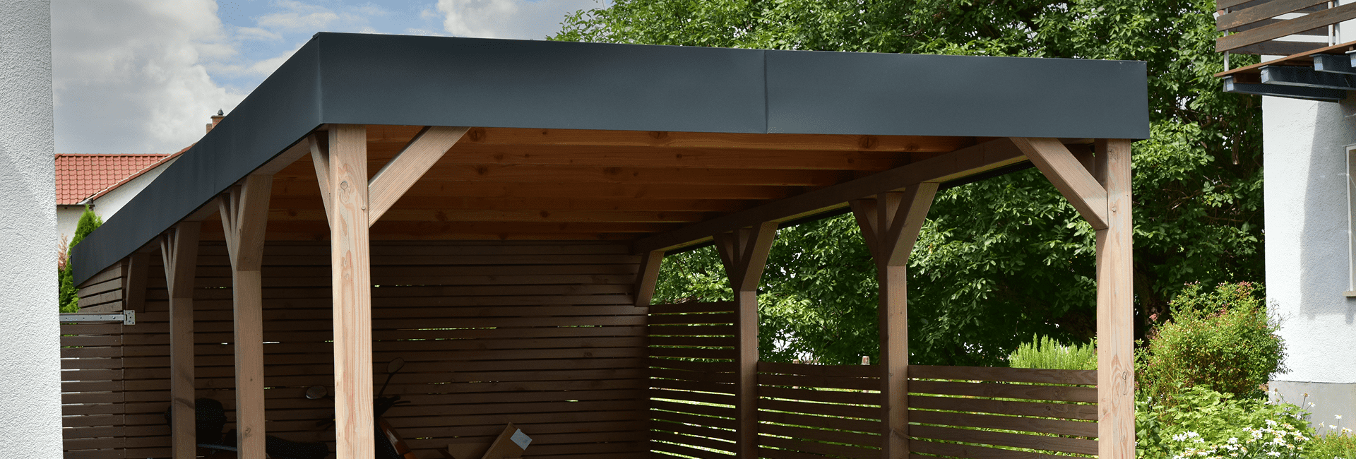 Carport Konstruktion aus Holz neben einem Haus